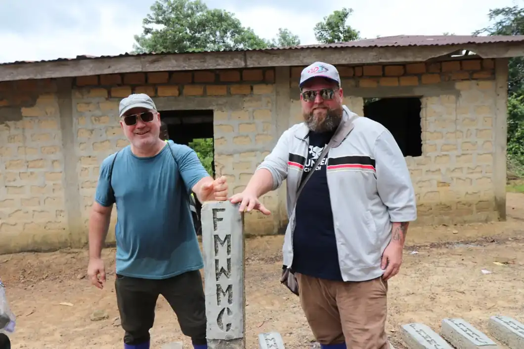 Visitors standing beside a Free Methodist World Missions marker