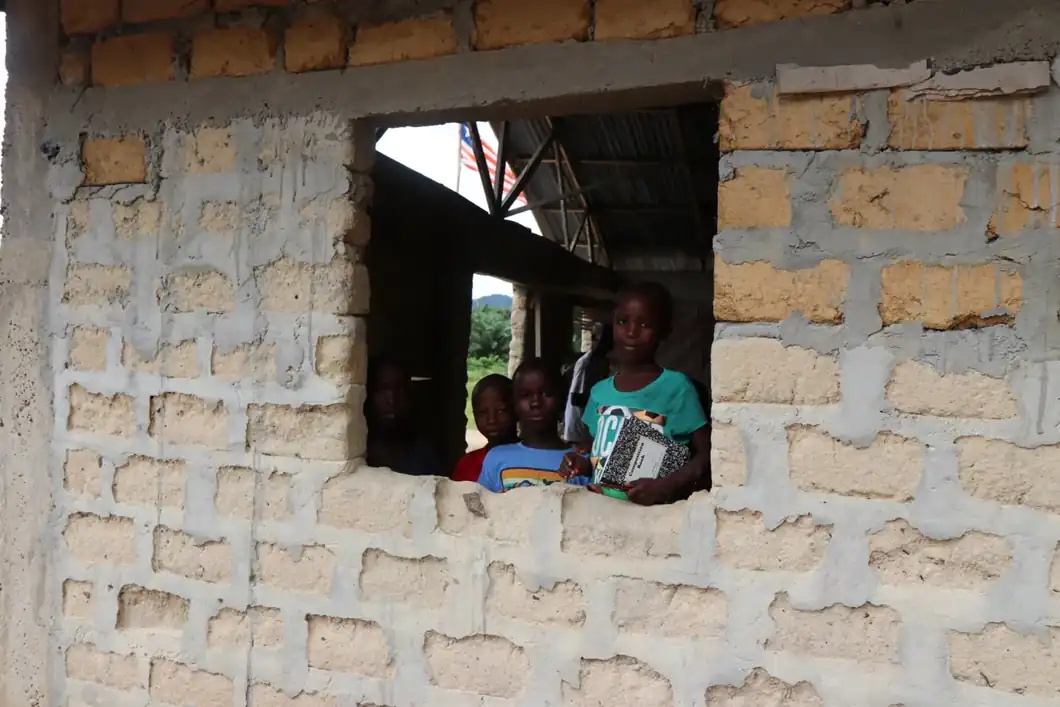 Children looking out from a classroom building